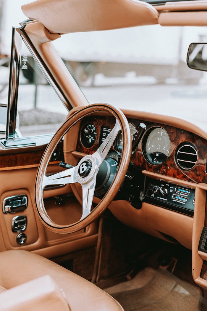 Explore a luxurious vintage car interior with a retro wooden dashboard and leather seats.